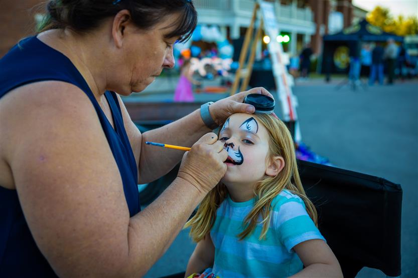 A girl gets her face painted
